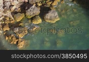Steinstrand am Meer/ Steine umspnlt von Wasser, Knste der Algarve, Portugal.