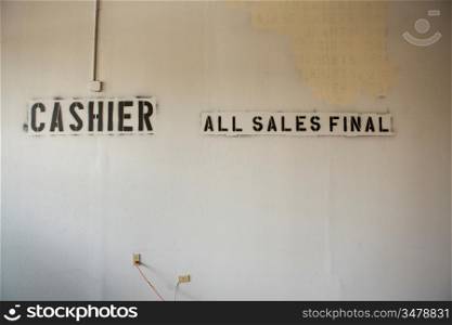 ""Stencil of ""Cashier All Sales Final"" on Abandoned Wall""