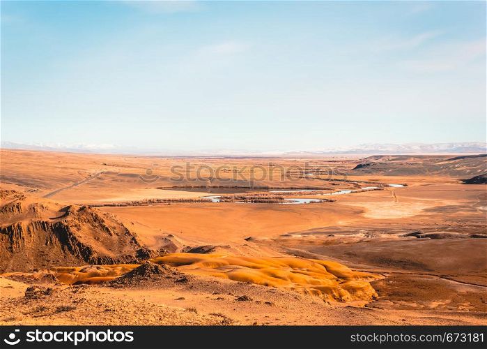 Steppe plain with yellow sand. Yellow soil under hot sun. Mountain empty valley. Travel Altai.