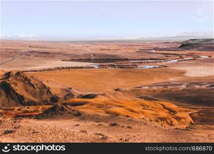 Steppe plain with yellow sand. Yellow soil under hot sun. Mountain empty valley. Travel Altai.