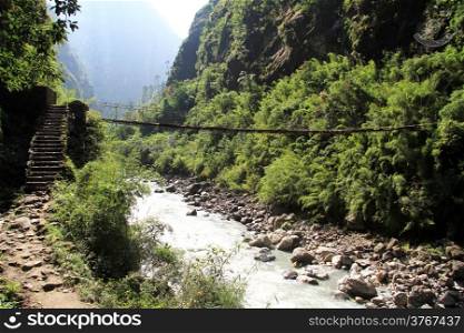 Steps and suspension bridge in mountain, Nepal
