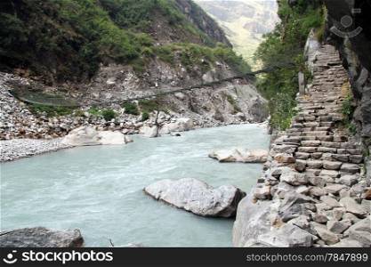 Steps on the footpath and suspension bridge in Nepal