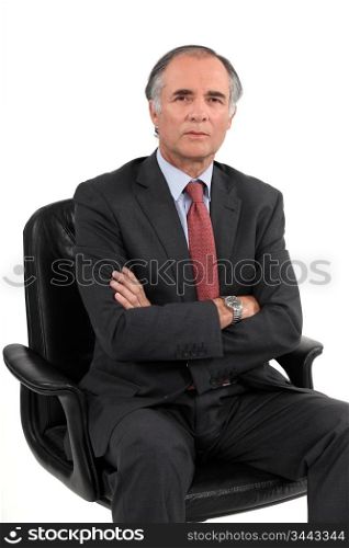 Stern businessman sat in office chair