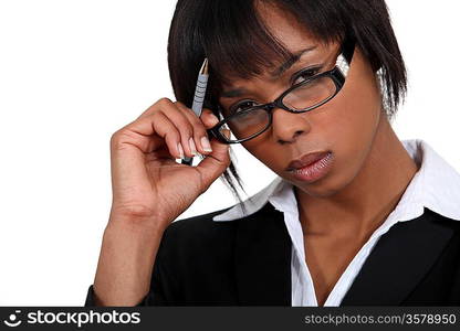 Stern businesswoman touching her glasses