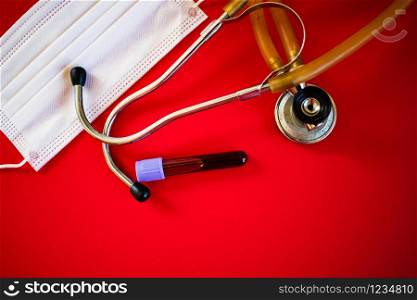 stethoscope and blood test sample on red coronavirus