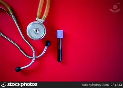 stethoscope and blood test sample on red coronavirus