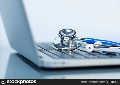 Stethoscope and laptop. Acoustic stethoscope on a laptop computer