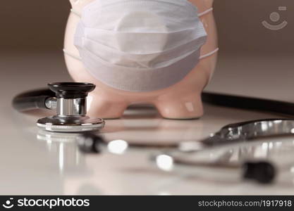 Stethoscope and Piggy Bank Wearing Protective Medical Face Mask.. Stethoscope and Piggy Bank Wearing Protective Medical Face Mask