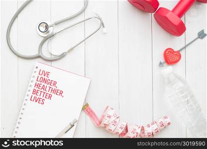 Stethoscope, fitness equipments on white wooden background, Flat lay Health and Diet plan concept