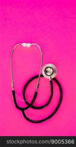 Stethoscope isolated on pink background with copy space