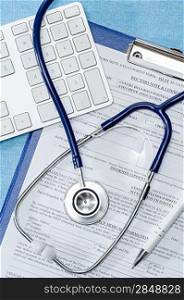 Stethoscope laying over doctors emergency report medical documentation