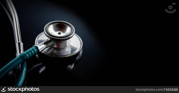 Stethoscope on a glass table, dark background, The concept of medicine and medical treatment