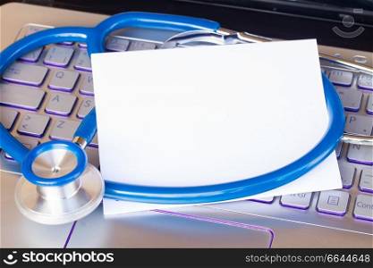 stethoscope on notebbok keyboard with copy space on blank note