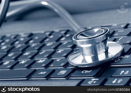 stethoscope on the laptop keyboard, blue toned