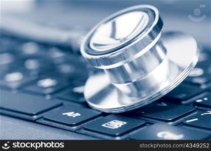 stethoscope on the laptop keyboard, blue toned