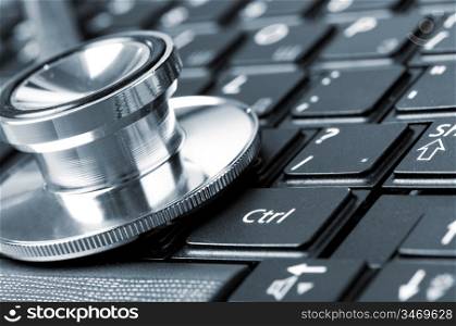 stethoscope on the laptop keyboard, close-up view, blue toned