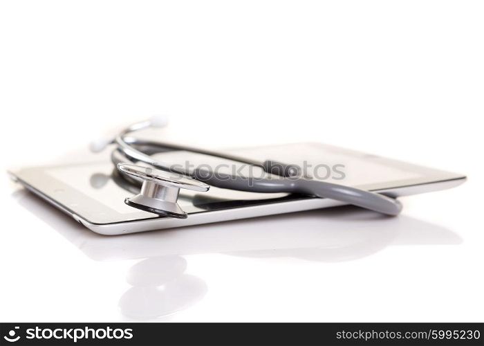 Stethoscope over a tablet computer, isolated over white background
