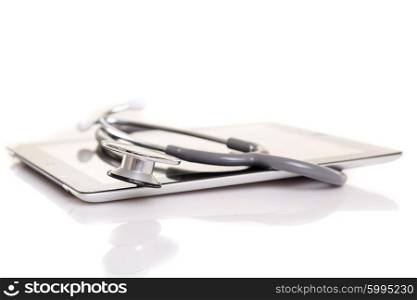 Stethoscope over a tablet computer, isolated over white background
