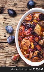 stew meat in plum sauce. meat stew in sauce of autumn plums on a retro background