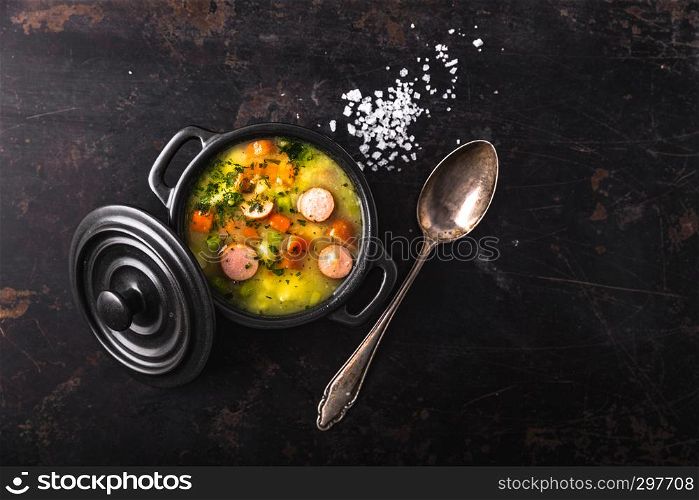 stew with fresh vegetables and sausages on a dark background