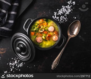 stew with fresh vegetables and sausages on a dark background