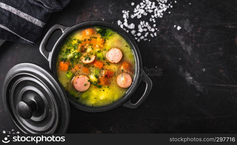 stew with fresh vegetables and sausages on a dark background