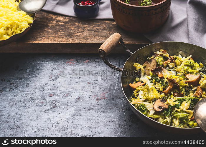 Stewed cabbage dish with mushrooms , preparation on dark rustic background