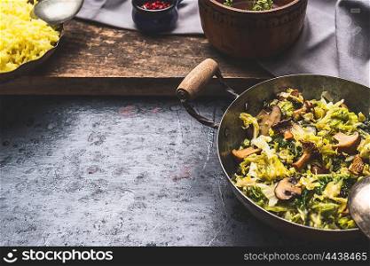 Stewed cabbage dish with mushrooms , preparation on dark rustic background