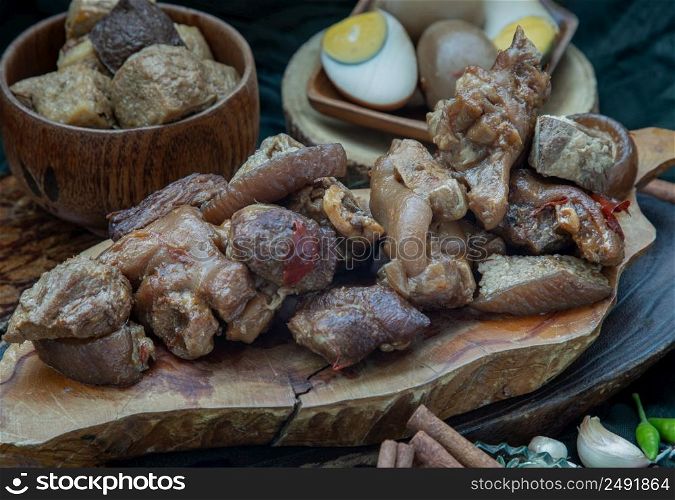 Stewed pork leg, Boiled eggs and Tofuwith Spices on wooden background. Selective focus.
