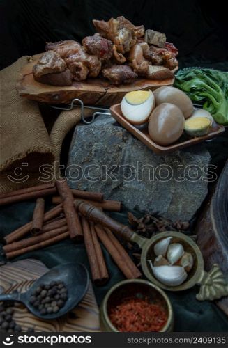 Stewed pork leg, Boiled eggs, Tofu and Kale with Spices on dark background. Selective focus.