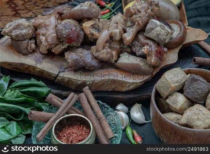 Stewed pork leg, Boiled eggs, Tofu and Kale with Spices on wooden background. Selective focus.