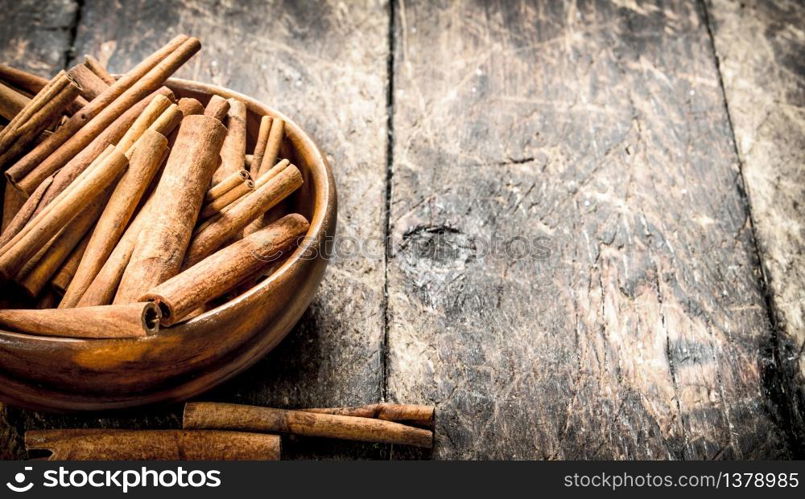 Sticks of cinnamon in a bowl. On wooden background.. Sticks of cinnamon in a bowl.