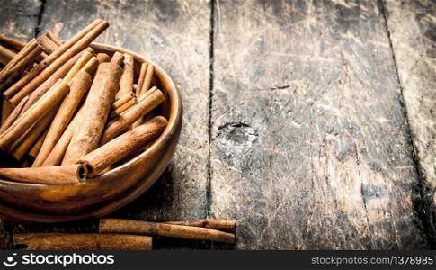 Sticks of cinnamon in a bowl. On wooden background.. Sticks of cinnamon in a bowl.