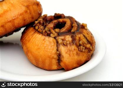 Sticky Bun. Cinnamon sticky buns on a white plate isolated on a white background