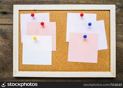 Sticky note on cork board on wooden wall background,empty space for text.