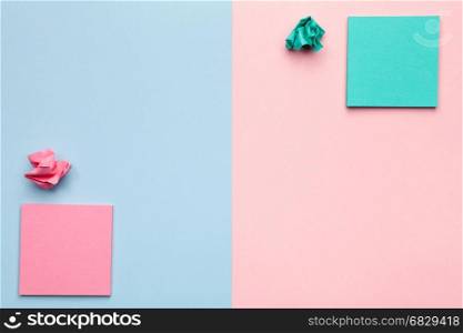 Sticky notes with crumbled paper balls on pastel background. Minimal style. Flat lay. Copy space. Top view