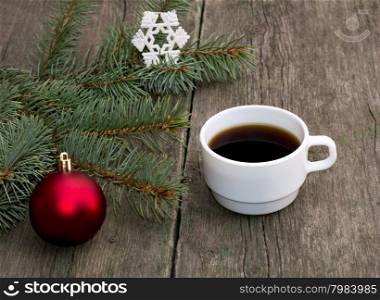 still life a fir-tree branch with brightly red ornament and a cup of coffee, a festive card, the subject Christmas and New Year