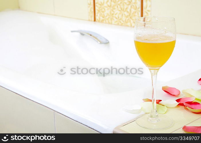 Still-life a glass with a drink against a bath with foam