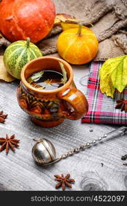 Still life autumn tea party. Autumn fragrant herbal tea and harvest decorative pumpkins