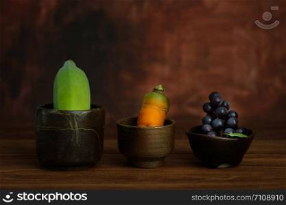 Still-life Banana, carrot, grapes are in a pottery cup on rustic wooden table, Choose a focal point.