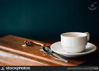 Still life cup of coffee or tea on retro wooden table, rustic and dark style