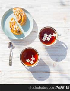 still life - cups of tea and bun on a wooden background. atmosphere and mood
