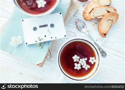 still life - cups of tea, crackers, books and tapes on a wooden background. atmosphere and mood
