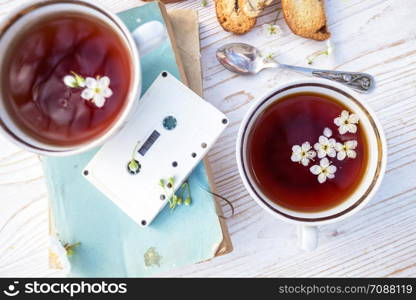 still life - cups of tea, crackers, books and tapes on a wooden background. atmosphere and mood