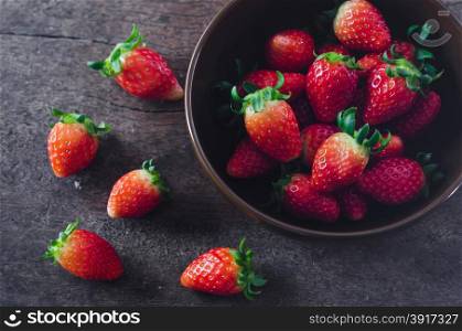 still life fresh strawberries in bow;l , over wooden background