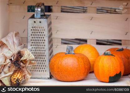 still life from autumn pumpkins, grater and corn
