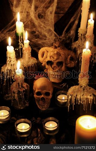 Still life from skulls on the book next to the environment of candles. concept of black magic. Halloween.