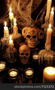 Still life from skulls on the book next to the environment of candles. concept of black magic. Halloween.