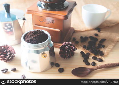 Still life ground coffee in coffee pot, Vintage coffee grinder and coffee beans on wooden table