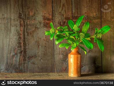 Still life image of dried flowers in rustic vase against weathered wooden background